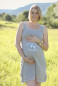 Preview: schwangere blonde Frau im Kleid mit Aufdruck Coming soon und Babyfüsse